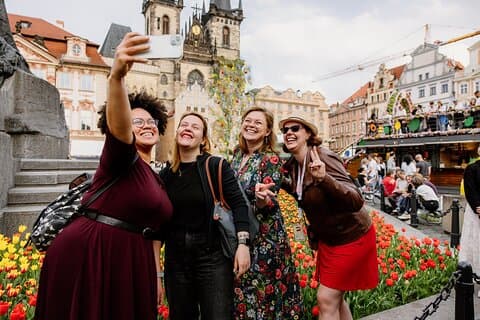 Guests on the Easter Markets Tour in Prague taking a selfie with their local tour guide at the main market in the Old Town Square