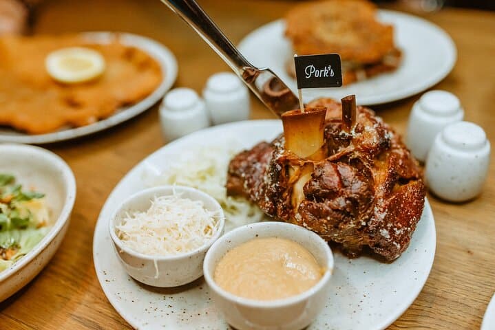 Traditional roasted pork knuckle with sides of mustard and horseradish