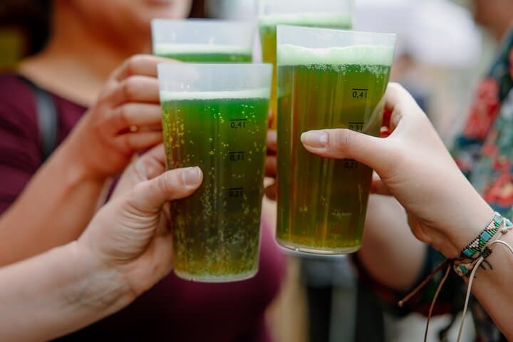 Raising a glass for a toast with season green beer during Easter