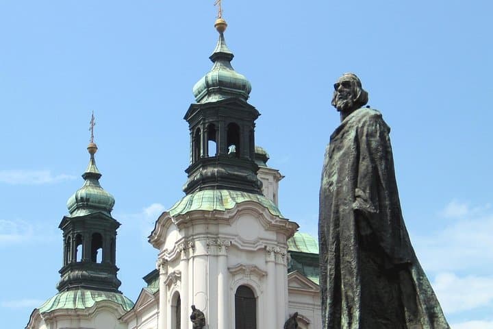 Jan Hus Monument with St. Nicholas' Church in the background ©CzechTourism
