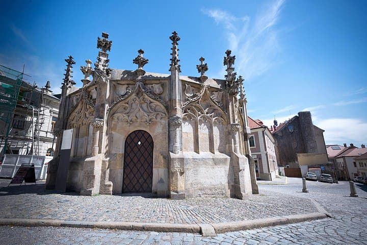A circular stone fountain stands as a quiet reminder of Kutná Hora’s medieval past in the town’s historic center.
