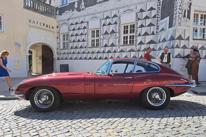 Jaguar E-type and house with graffiti behind, veteran meeting in Mikulov