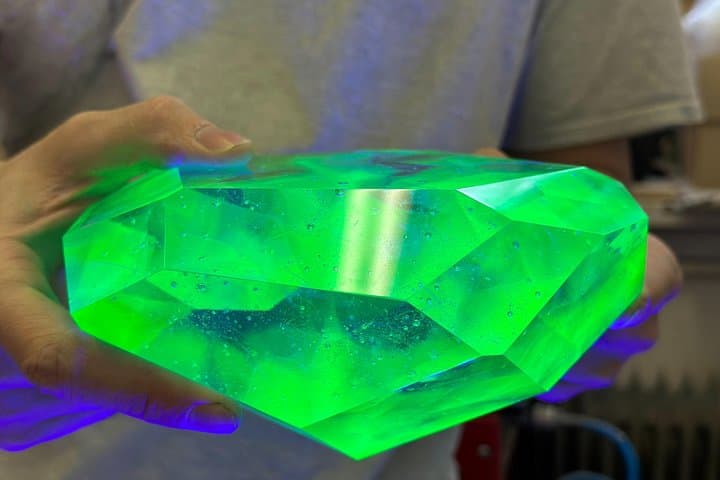 Formed by molten glass in a mold, with tiny bubbles adding depth. Cut and polished to perfection, this uranium glass glows under UV light—and faintly, almost magically, on its own.